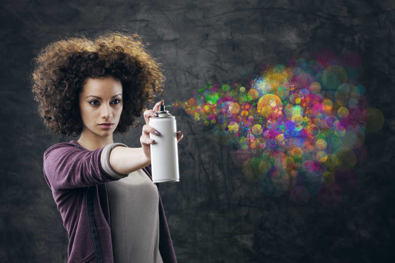 灰色背景前爆炸头的个性女孩在展示彩色涂鸦