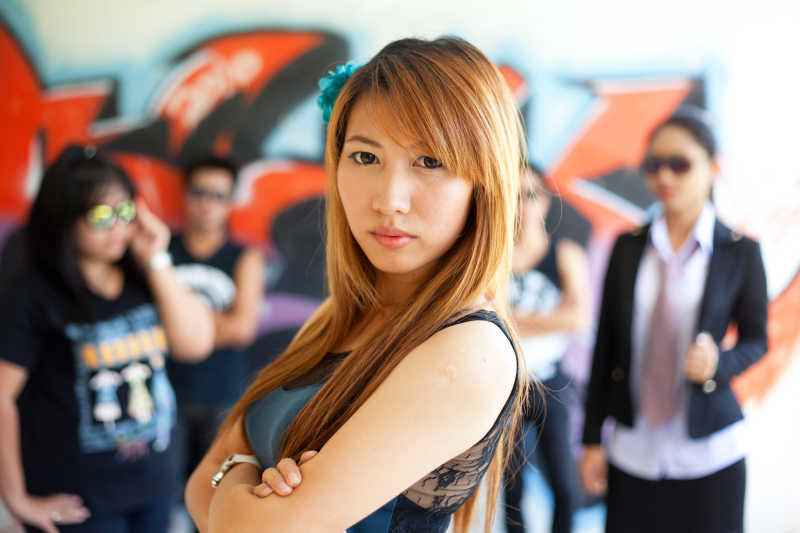 站在涂鸦中的帮派群众前自信的女人
