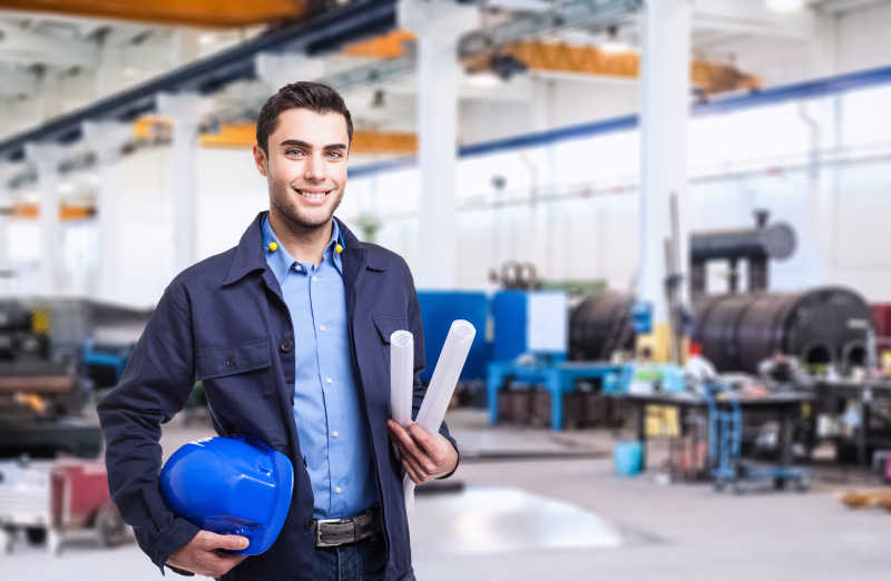 工厂背景下拿着蓝帽子微笑的工男性工人