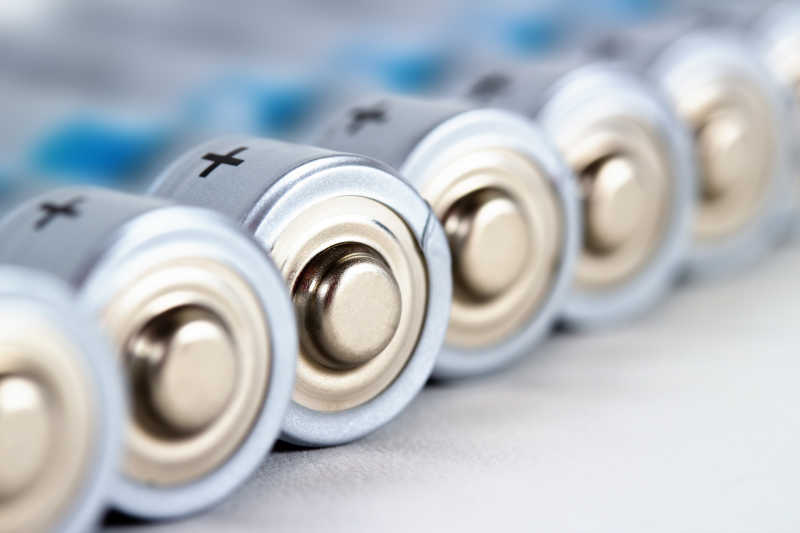 白色桌面上排列整齐的AA电池