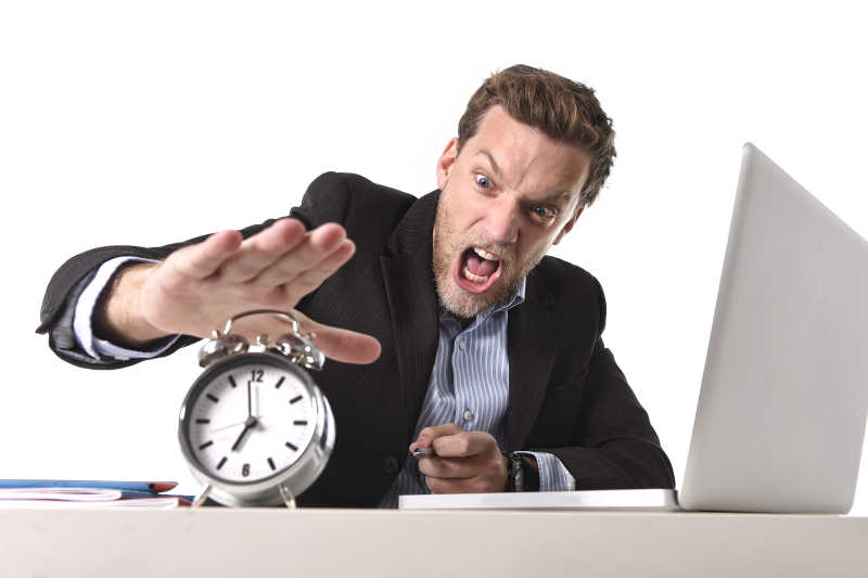 在闹铃和笔记本前崩溃的年轻人