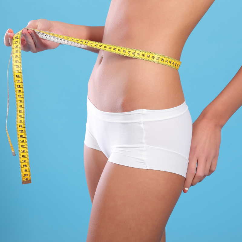 用卷尺量腰围的美女