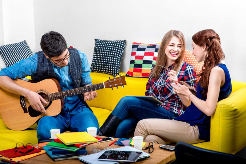 沙发上弹吉他的年轻人