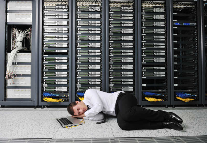 修理网络服务器机房故障的劳累睡着的技术人员