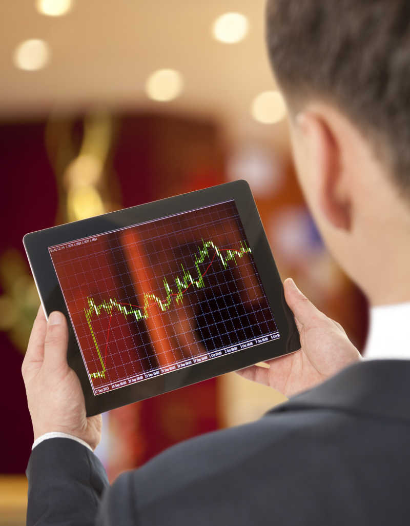 手持平板电脑的商人关注股票市场