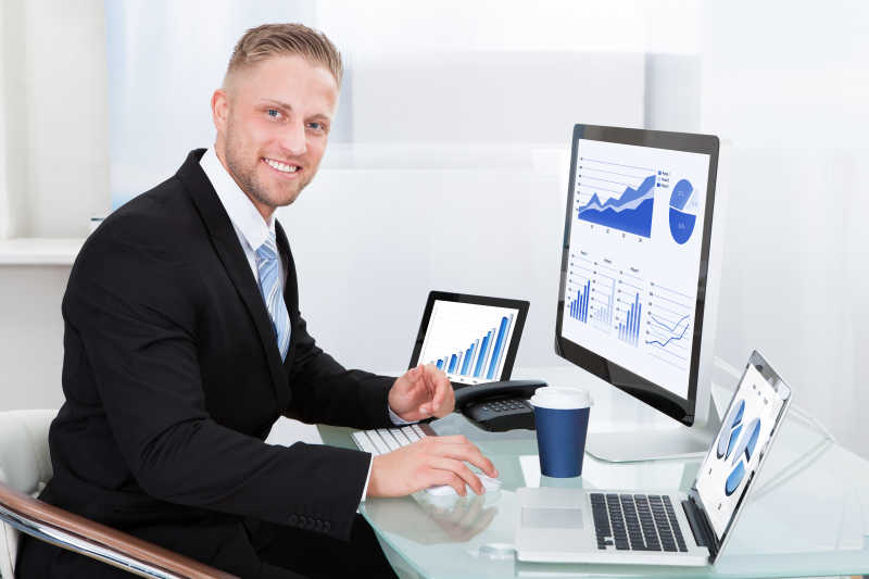 证券经纪人坐在电脑前分析股票走势