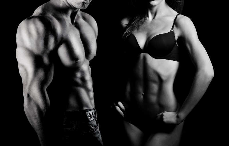 黑色背景下健美健身男女展示完美的身材
