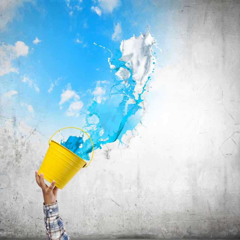 对墙上泼蓝色油漆的人