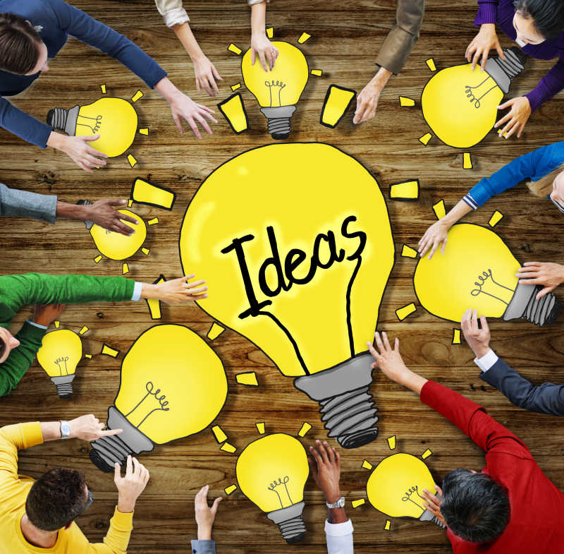 伸出手去摸桌子上灯泡图案的人们