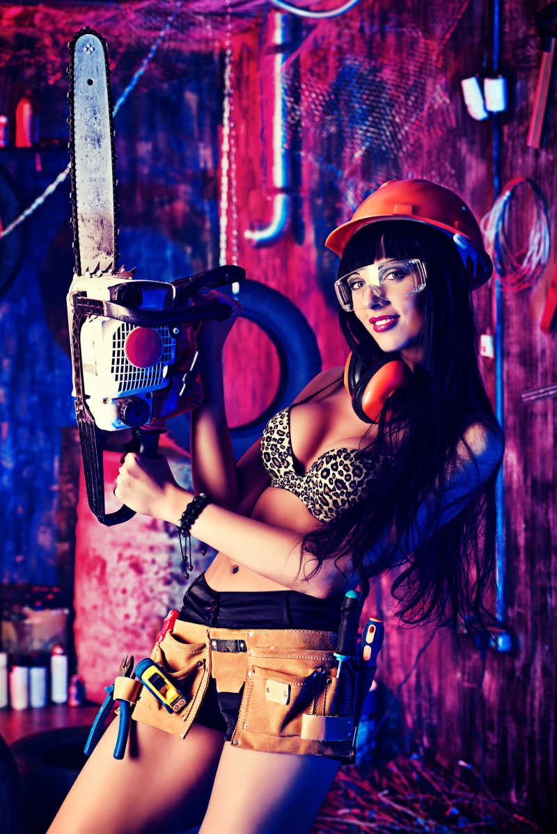 穿比基尼的性感女孩拿着电锯