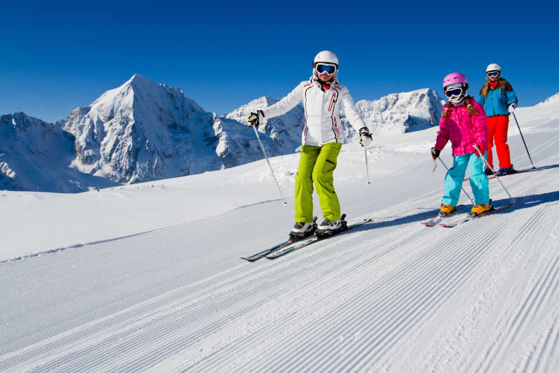 正在山坡滑雪的大人与小孩