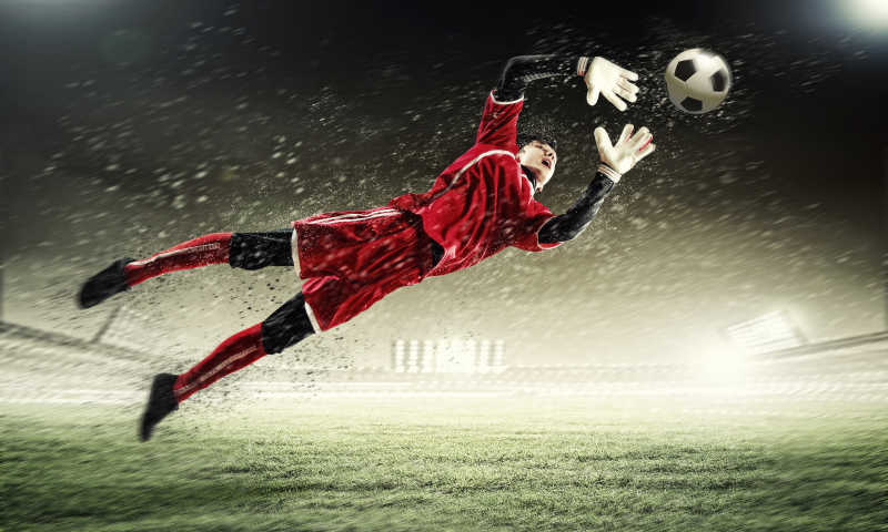 在雨中飞身接球的足球运动员
