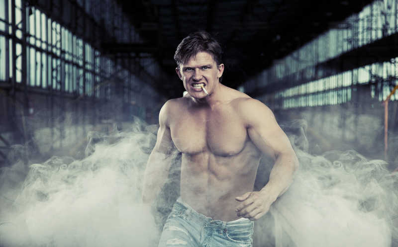 英俊健壮的男人嘴里叼着香烟