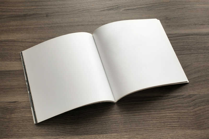 木色纹理桌面上打开的空白日记本