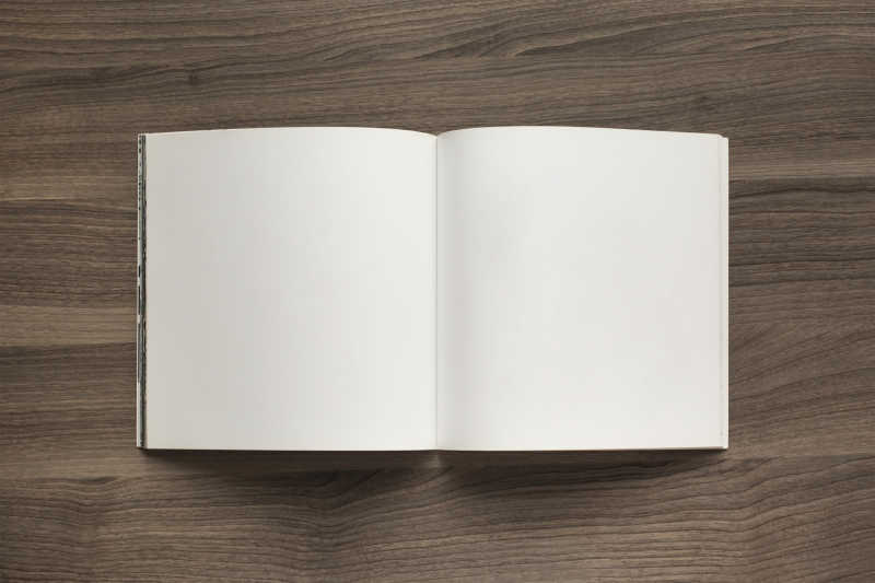 木质桌面上打开的白色小册子