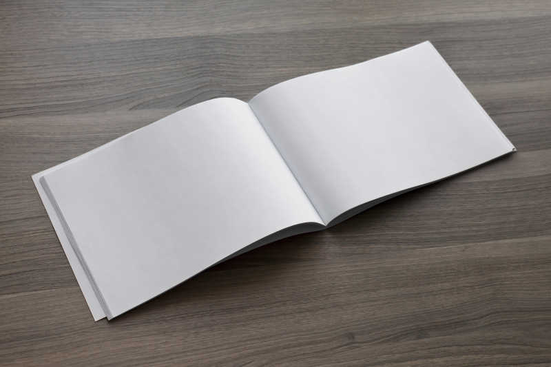 木制桌面上打开的空白日记本