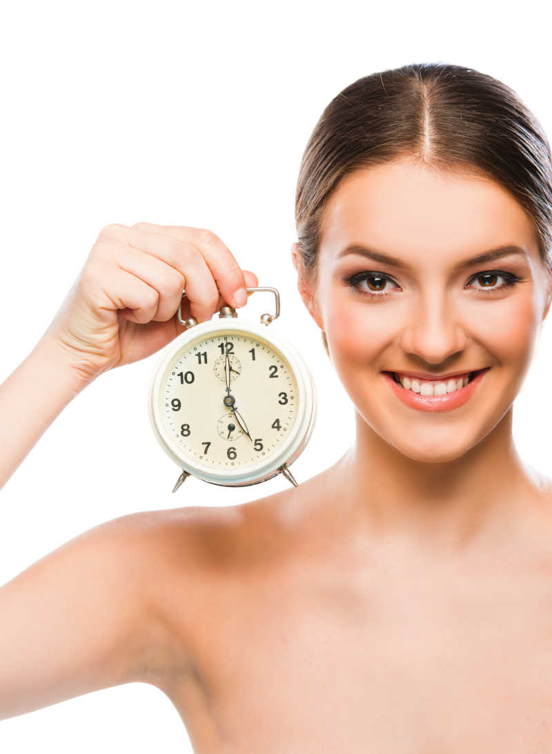 拿着闹钟在笑的美女