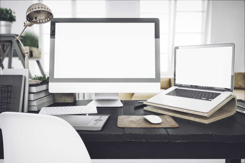 办公桌上的笔记本和台式电脑