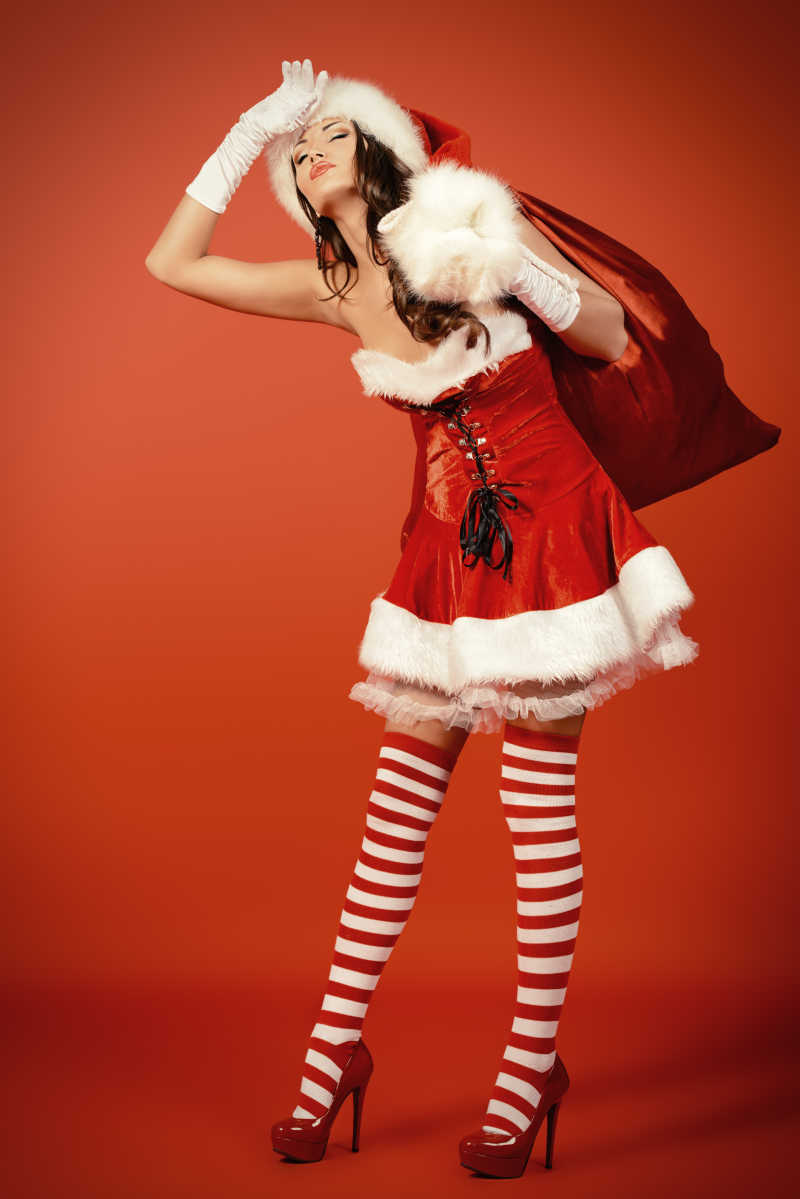 身穿圣诞服饰背着红色袋子的美女