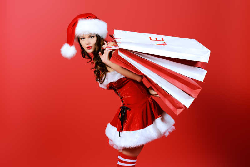 身穿圣诞服饰手拿购物袋的美女