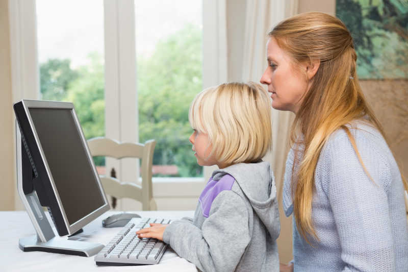 可爱的女儿和妈妈使用电脑