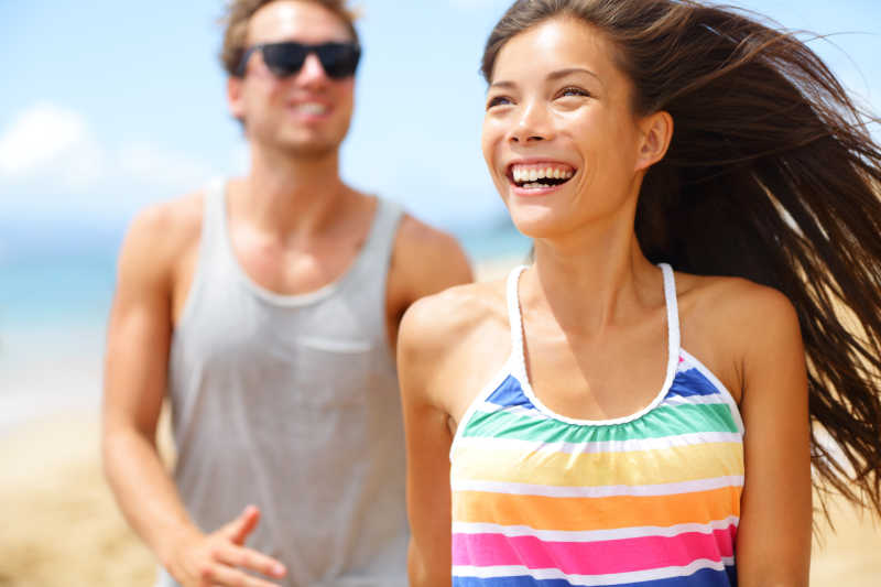 年轻快乐的情侣在沙滩上欢笑