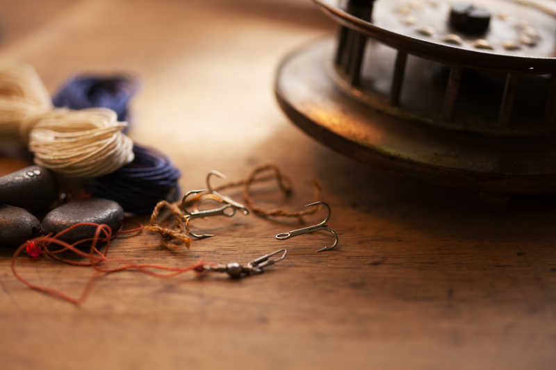 老式捕鱼卷和老木桌上的三钩