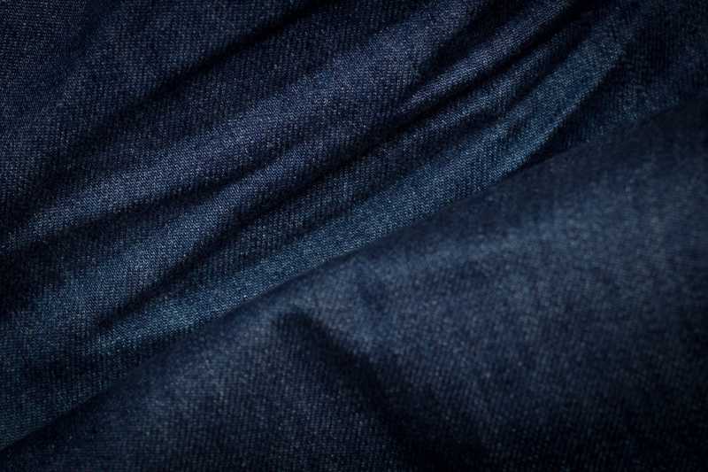 褶皱的蓝黑色牛仔裤纹理