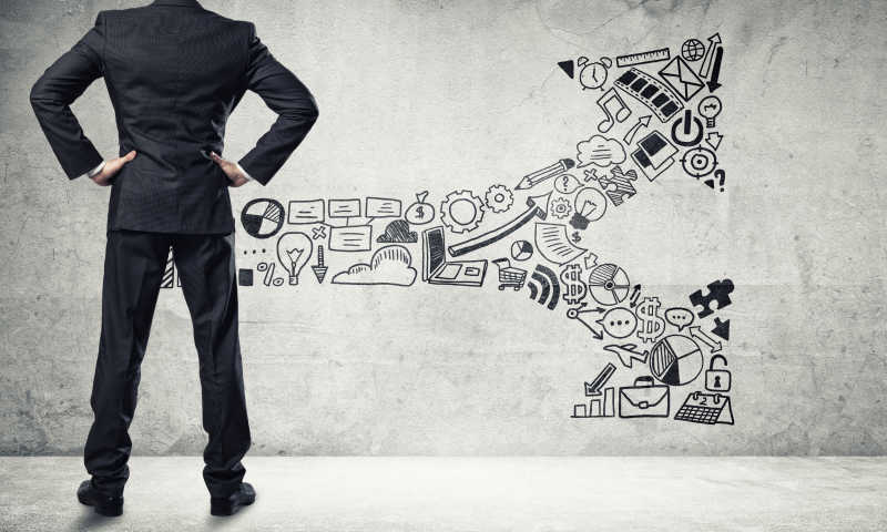 商人面对着墙上的双箭头涂鸦