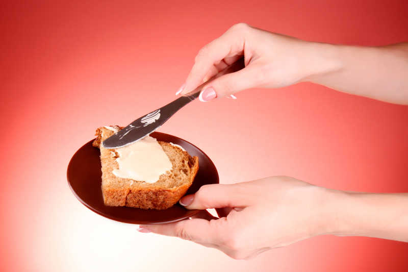 女人的双手涂黄油面包