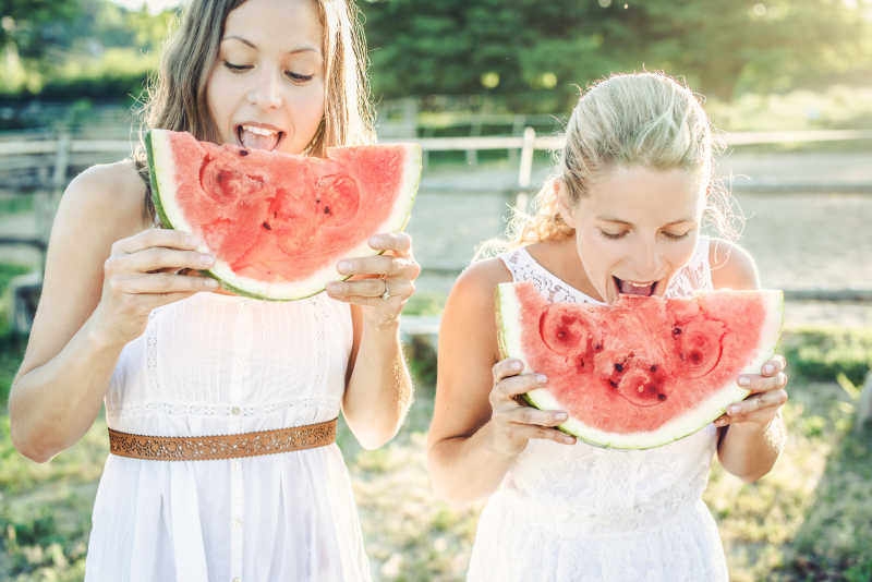 两个美女开心地吃着西瓜