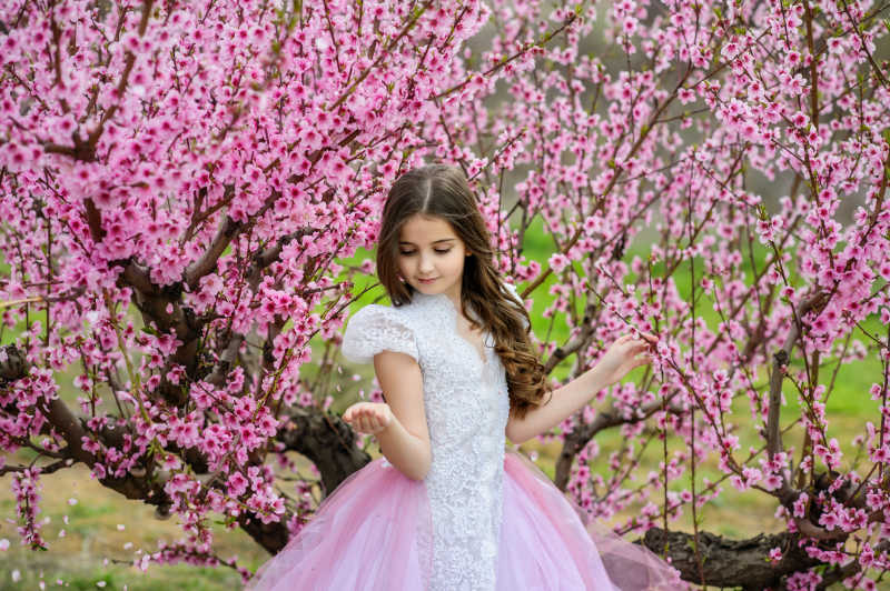 桃花树下穿着白色衣服的小女孩