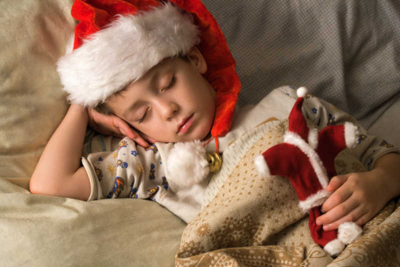戴着圣诞帽睡着的可爱儿童