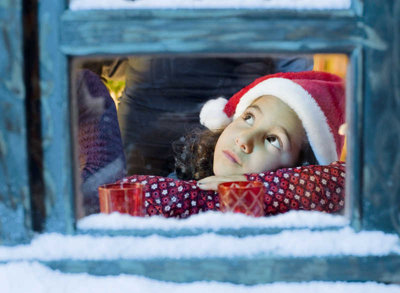 趴在窗户口的圣诞小女孩