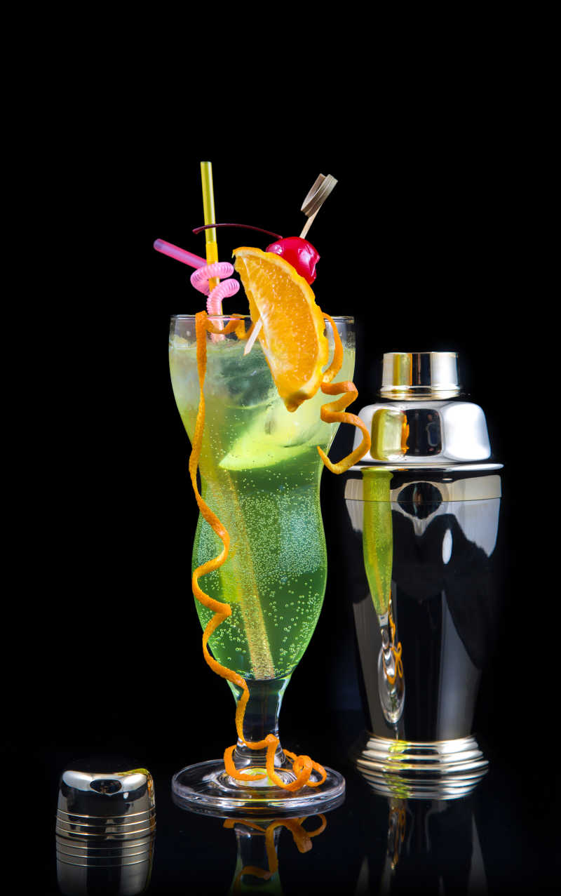 黑色背景上的美丽鸡尾酒和调酒器