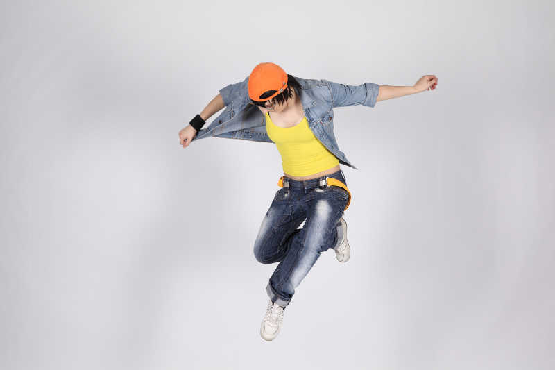 灰色背景上跳舞的年轻女人