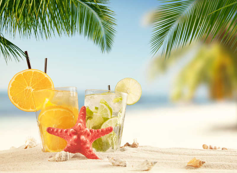 沙滩上的两杯柠檬饮料和海星
