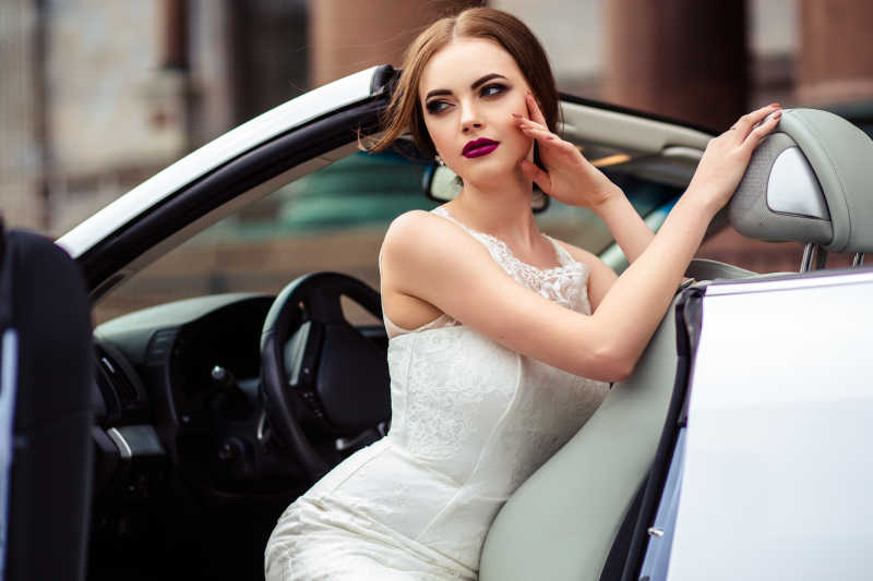 扶靠在跑车上的新娘