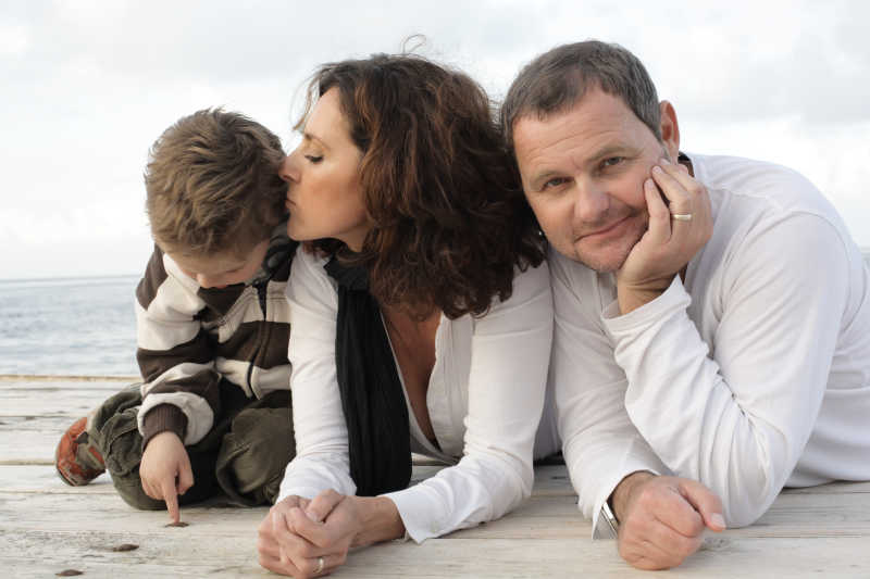 趴在户外地上的一家三口