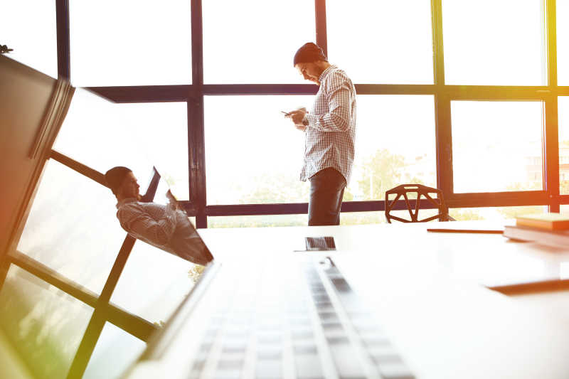 办公室内的男人与桌上的笔记本电脑