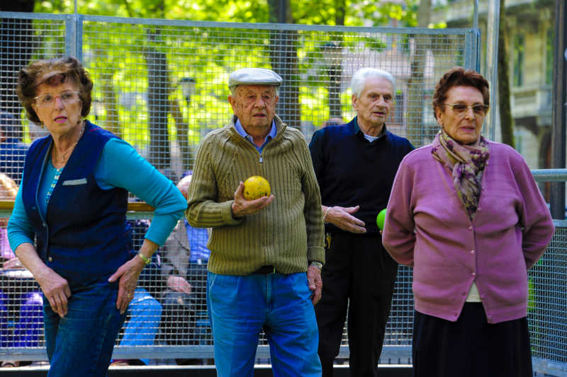 老人和妇女一起玩滚球在室外公园