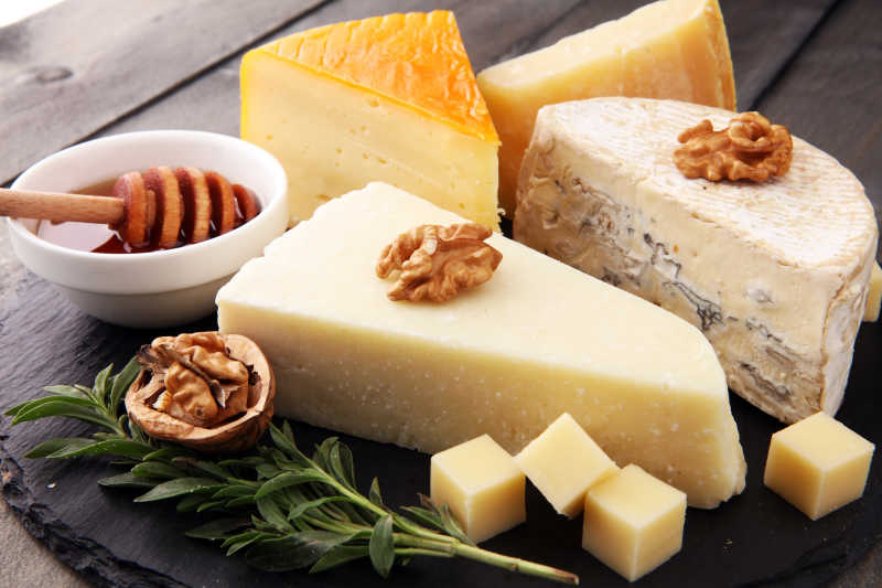 木板上的各种美味奶酪和配料