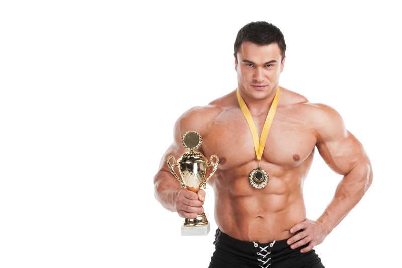 健壮肌肉发达的运动员获奖金牌和金杯