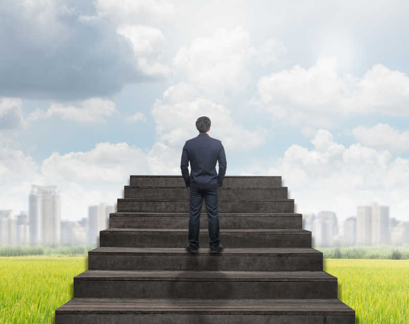 商人站在云端和天空背景下的楼梯上