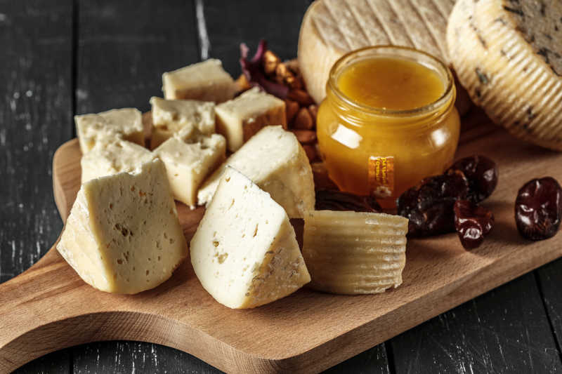 木板上的奶酪蜂蜜和大枣