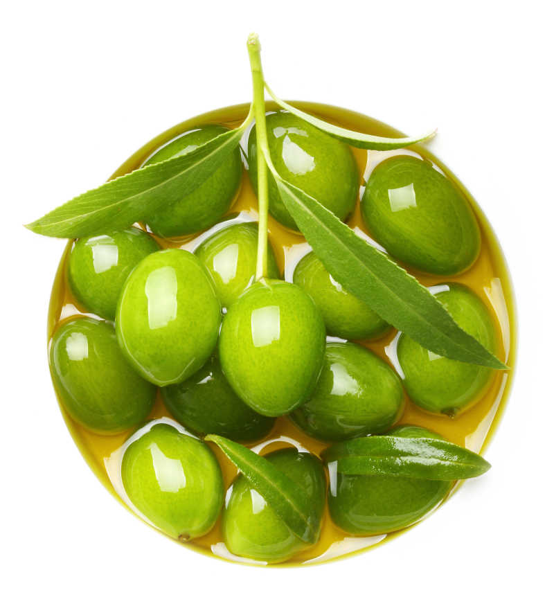 白色背景下木盘里的橄榄油和橄榄果