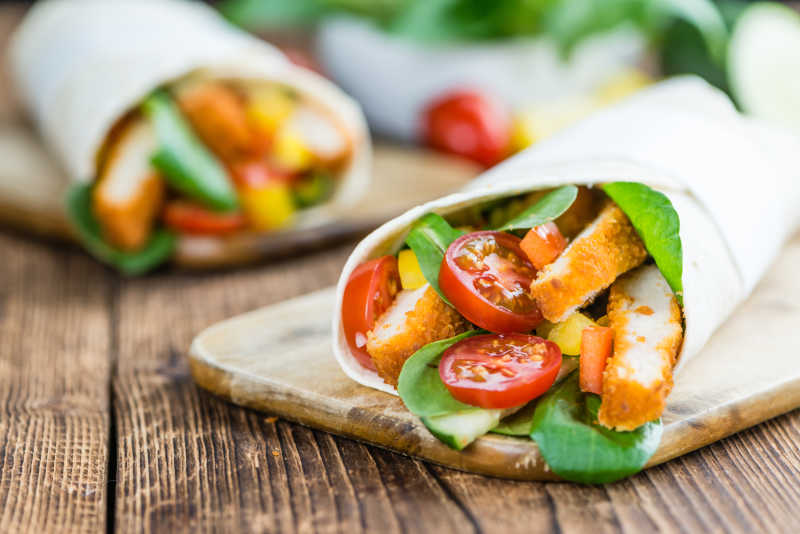 木桌木盘上卷起来的鸡味块美食