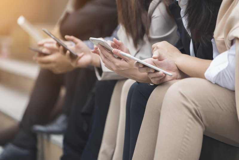 年轻人坐着使用智能手机