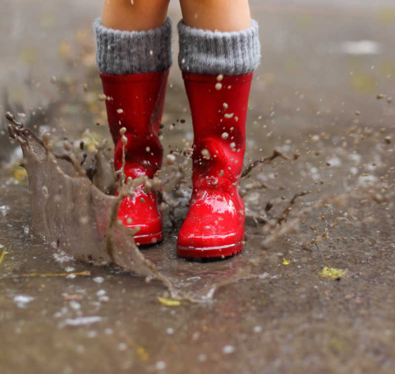 小孩穿雨靴踩泥图片
