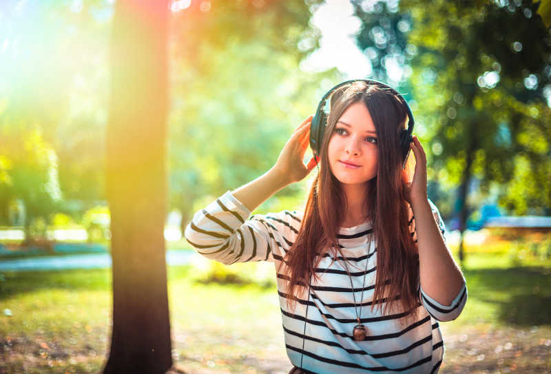 在树林里戴耳机的美女